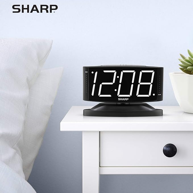 Sharp Digital Alarm Clock with Swivel Base, White LED, Dimmer, Black | Large white LED digits; Adjustable swivel base; Brightness dimmer; Snooze alarm; Simple controls; black case