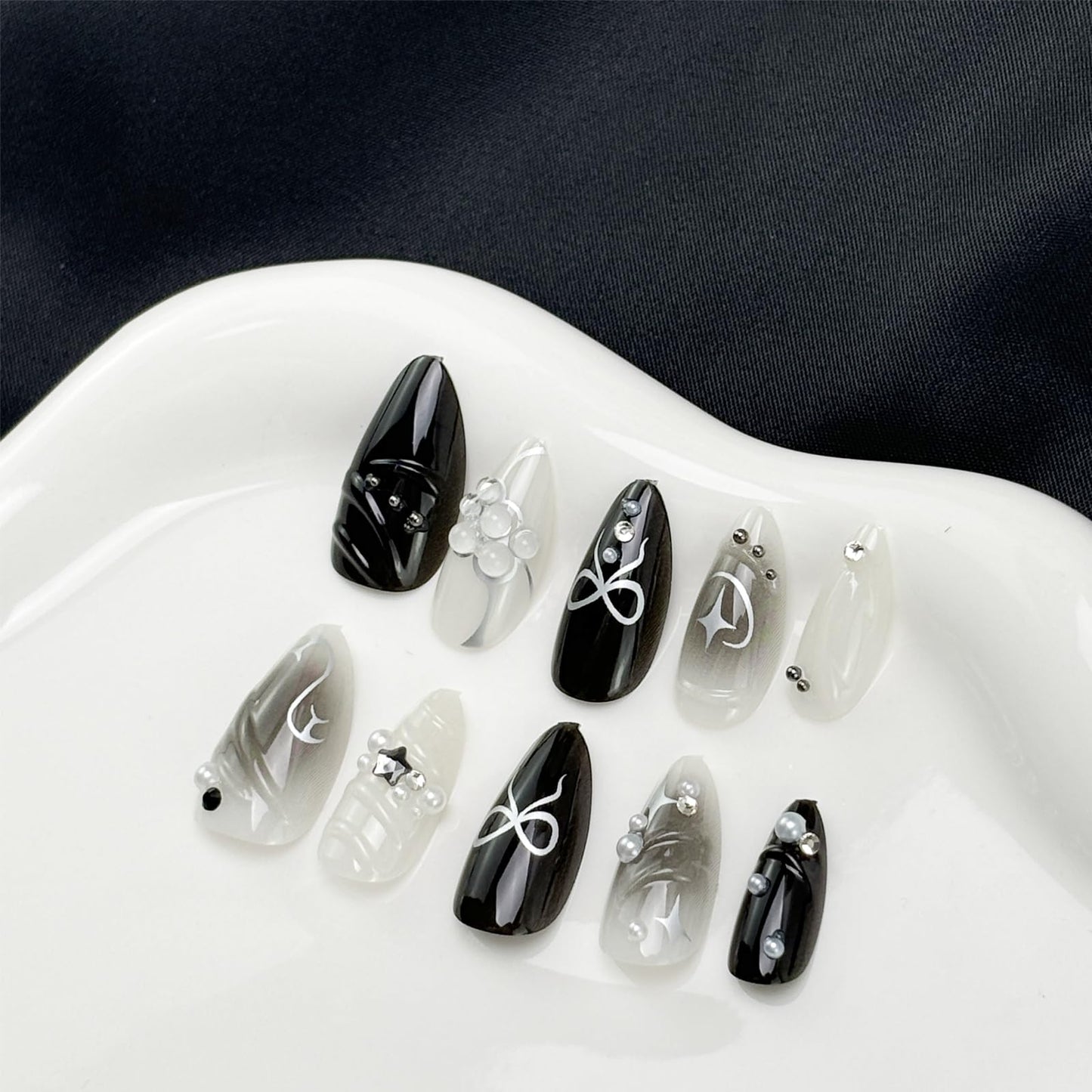 LBPEPAMZ Black Press on Nails Medium Almond Fake Nails with 3D Alloy Bow Pearl Designs Black Gradient Full Cover False Nail Water Drops Silver Star Glossy Acrylic Nails Stick on Nail for Women 24Pcs