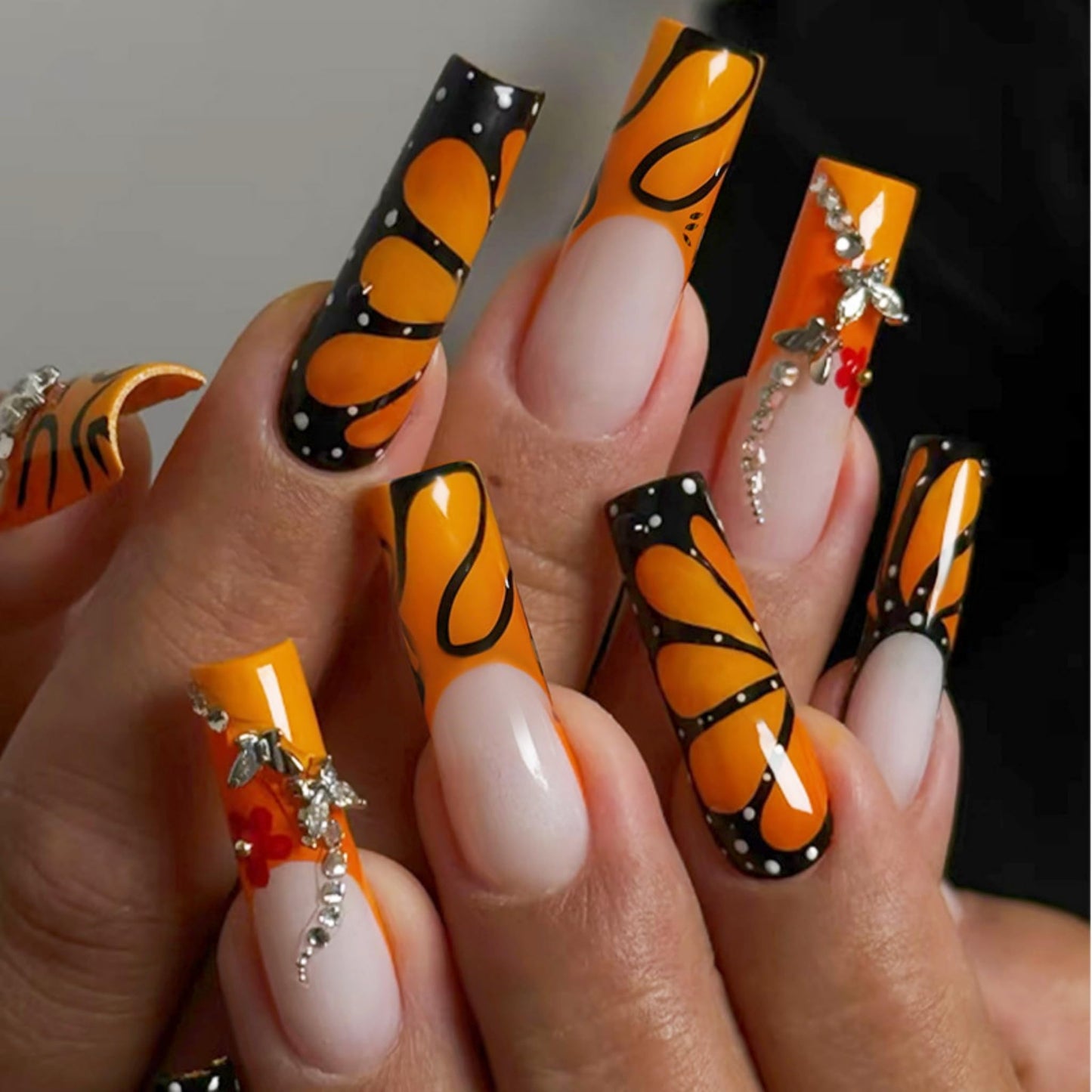 Long Press on Nails Square Fake Nails Orange Acrylic Nail Press Ons Seeneey Black Butterfly and Silver Charm Designs Flowers Stick on Nail for Women 24pcs