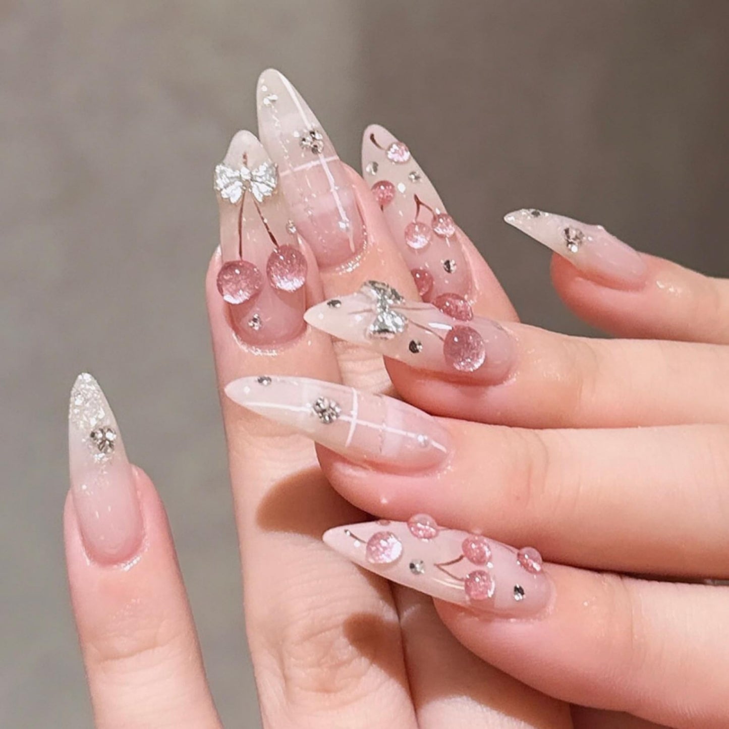 Long Press on Nails Almond Fake Nails Nude Pink Artificial Nail with 3D Cherry Silver Bow Rhinestone Design Stick on Nail for Women 24pcs