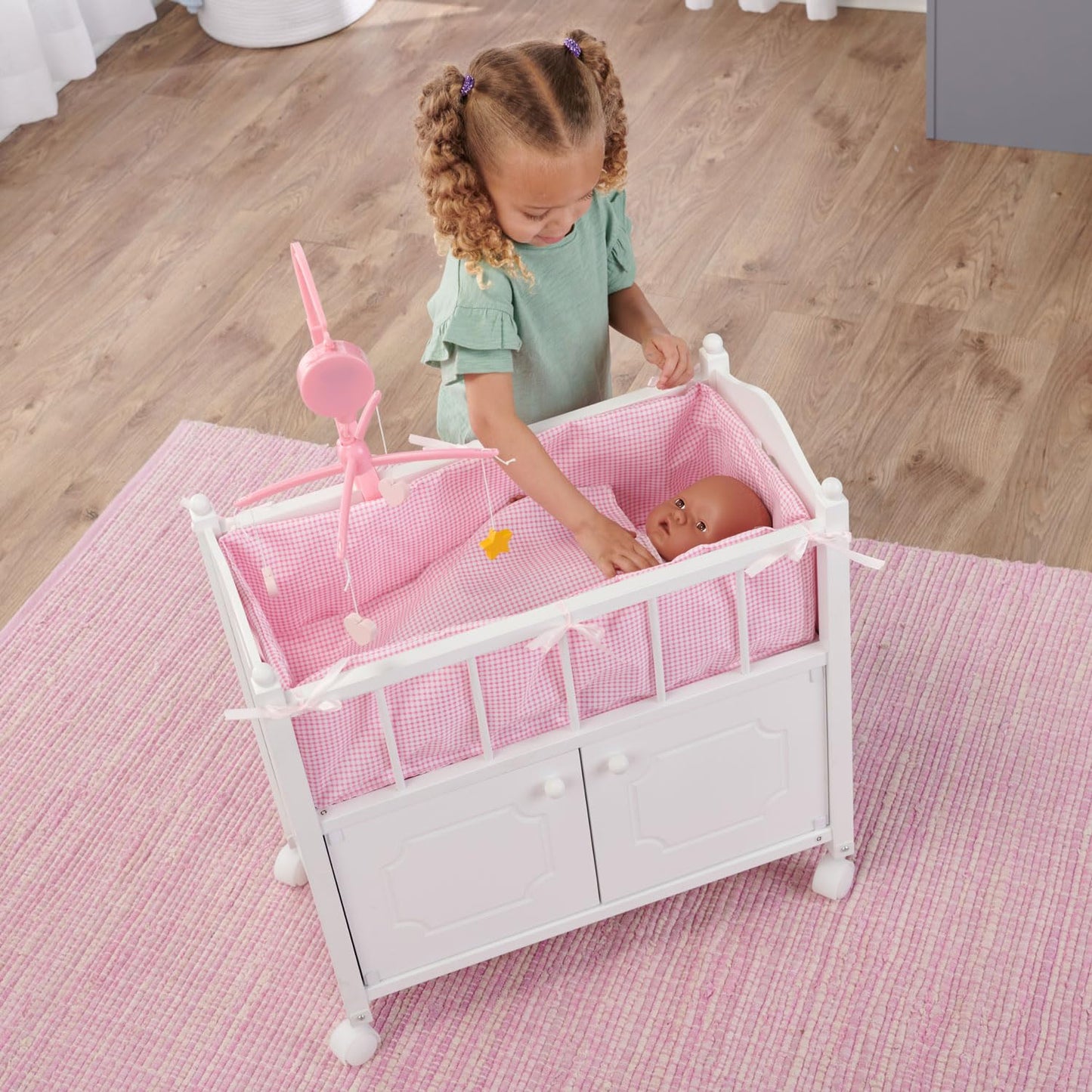 Badger Basket Wooden Toy Doll Bed with Storage, Mobile, and Bedding to Pretend and Play - Includes Wheels and Free Personalization Kit - White with Pink Gingham Fabric